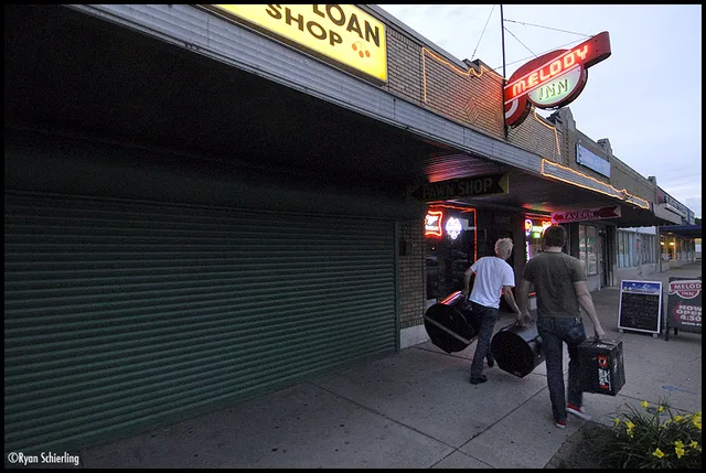 Spanish for 100 members carrying gear into the Melody Inn in Indianapolis on June 10, 2007; venue sign is clearly visible.
