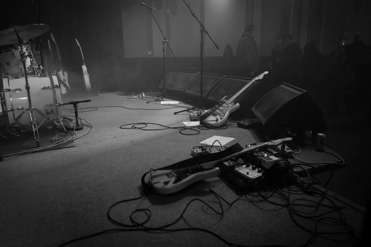 A stage set with drums, guitars, microphones, monitors, and effects pedals at the High Dive in Seattle.