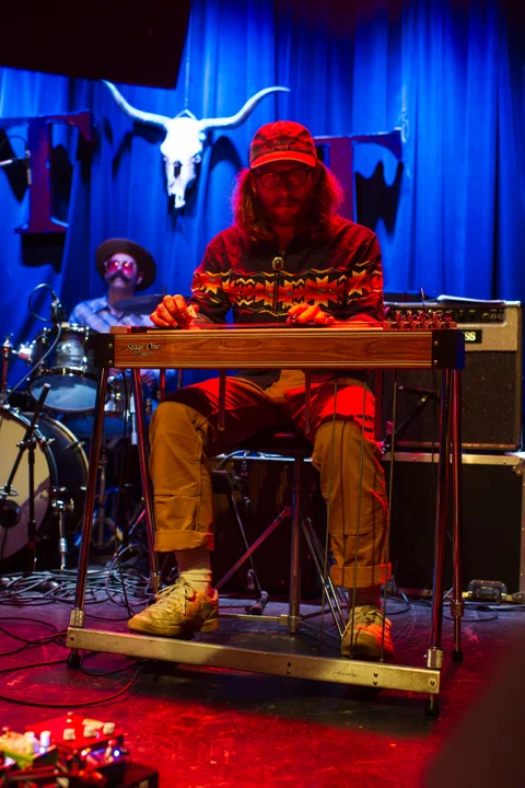 Seated musician playing pedal steel guitar at the 2025 Jason Molina MusiCares benefit.