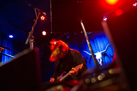 Guitarist leaning into a performance, seen across the stage at the 2025 Jason Molina MusiCares benefit.