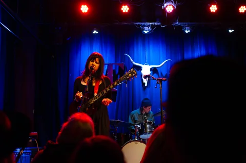 Guitarist and drummer on stage at the 2025 Jason Molina MusiCares benefit.