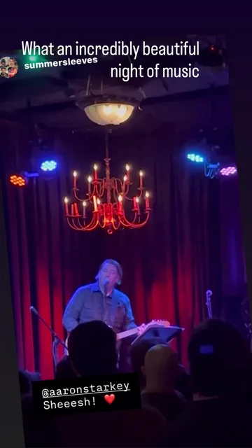 Aaron Starkey performing guitar onstage beneath red chandeliers at Tractor Tavern during the 2026 Justin Townes Earle Tribute.