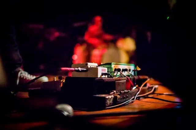 Effects pedals in focus with the drummer behind. The Trouble Starts, East release show, August 16, 2013.