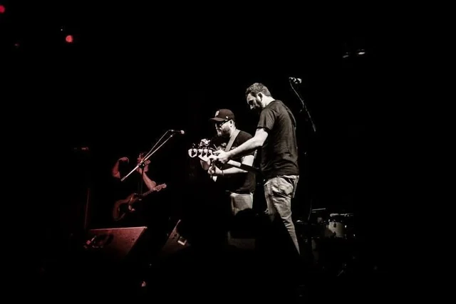 Wide black-and-white view of musicians performing. The Trouble Starts, East release show, August 16, 2013.