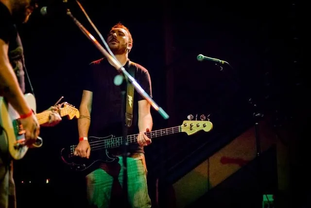 Bassist at a microphone beside a guitarist under stage lights. The Trouble Starts, East release show, August 16, 2013.