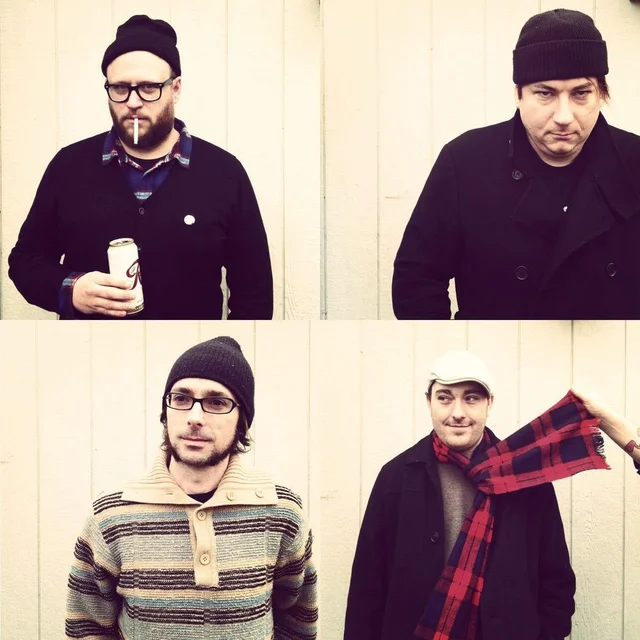 Four-panel portrait of The Trouble Starts band members against a cream-colored wall.