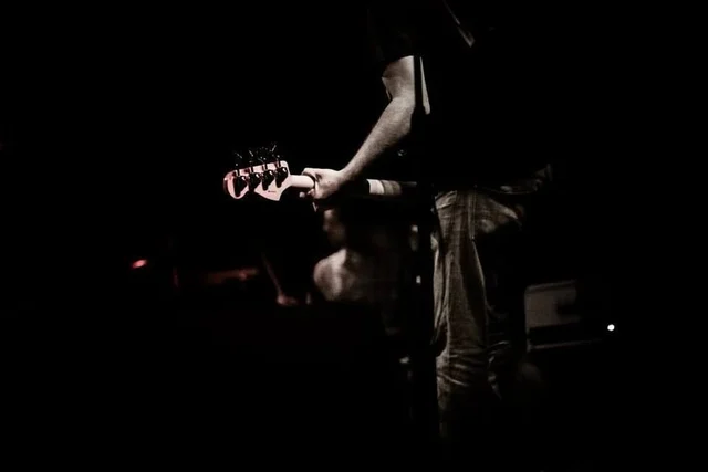 Black-and-white detail of a guitarist playing. The Trouble Starts, East release show, August 16, 2013.