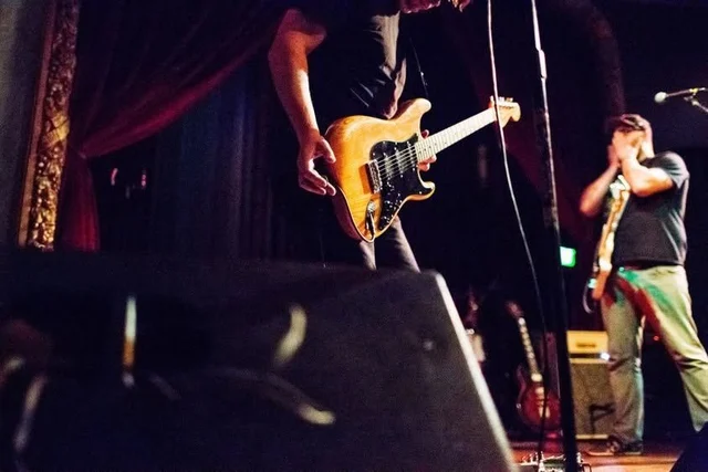 Low-angle view of musicians and stage monitors. The Trouble Starts, East release show, August 16, 2013.