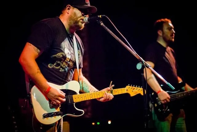 Guitarist and bassist performing together at microphones. The Trouble Starts, East release show, August 16, 2013.